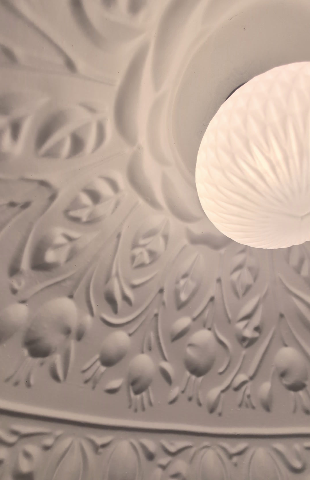 Close-up of the rosehip berry relief running around the lamp dome